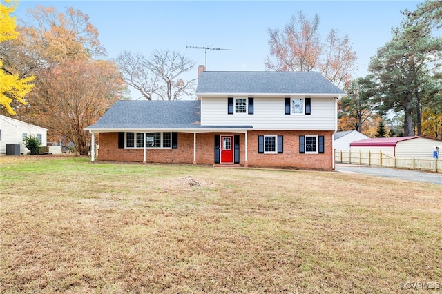 view of front of house with central AC and a front yard