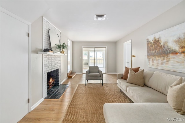 living room with wood-type flooring and a fireplace