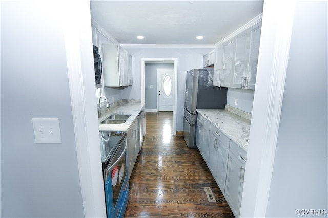 kitchen featuring white cabinetry, sink, stainless steel appliances, dark wood-type flooring, and light stone counters