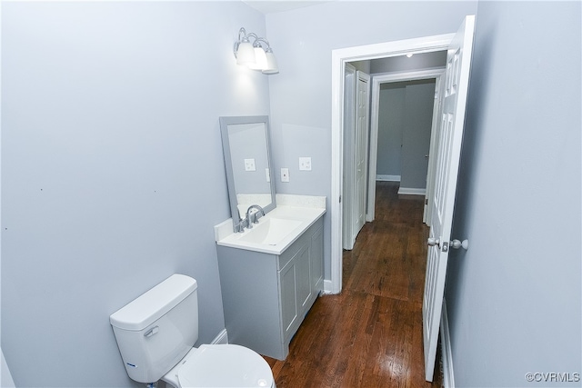 bathroom with hardwood / wood-style flooring, vanity, and toilet