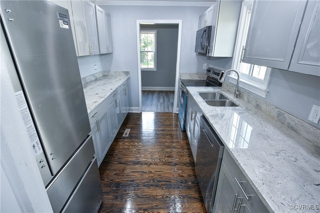 kitchen with light stone countertops, sink, dark wood-type flooring, stainless steel appliances, and white cabinets