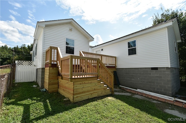 rear view of property with a lawn and a deck