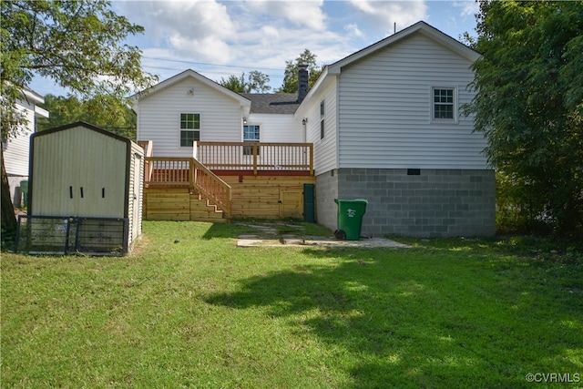 rear view of house featuring a yard, a deck, and a storage unit