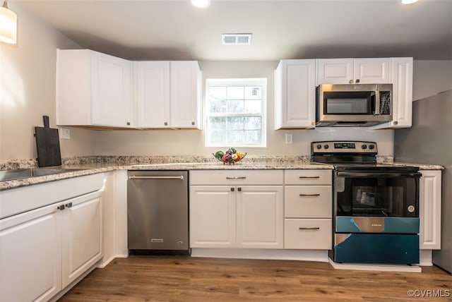 kitchen featuring light stone countertops, white cabinetry, and appliances with stainless steel finishes