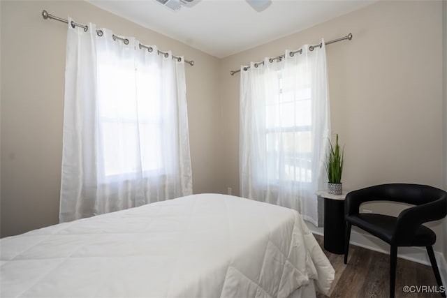 bedroom featuring ceiling fan, wood-type flooring, and multiple windows