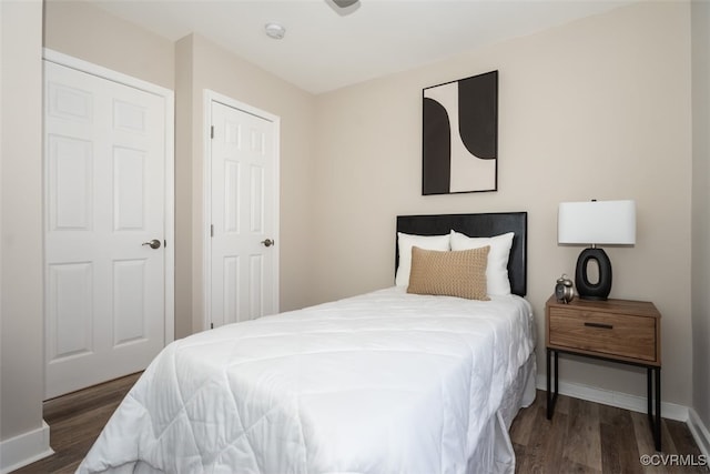 bedroom with dark hardwood / wood-style flooring