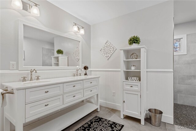 bathroom featuring tile patterned floors, vanity, and a tile shower