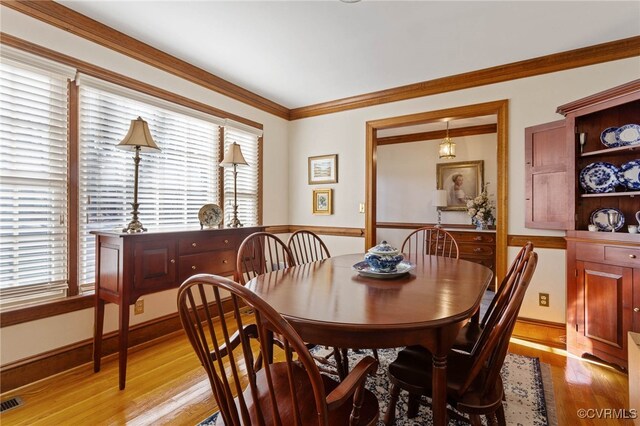 dining room with light hardwood / wood-style floors and ornamental molding