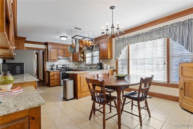 tiled dining space featuring a chandelier, sink, a healthy amount of sunlight, and ornamental molding