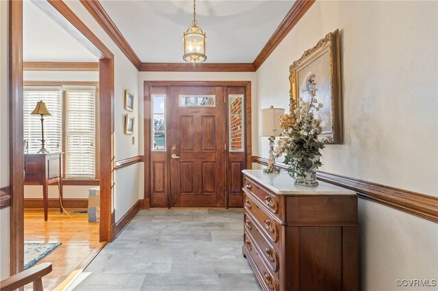 foyer entrance featuring ornamental molding and light wood-type flooring