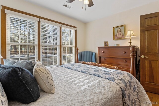 bedroom featuring hardwood / wood-style flooring, multiple windows, and ceiling fan