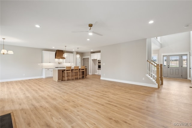 unfurnished living room featuring ceiling fan and light hardwood / wood-style floors