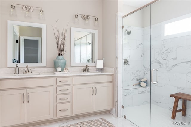 bathroom with double vanity, a shower stall, and a sink