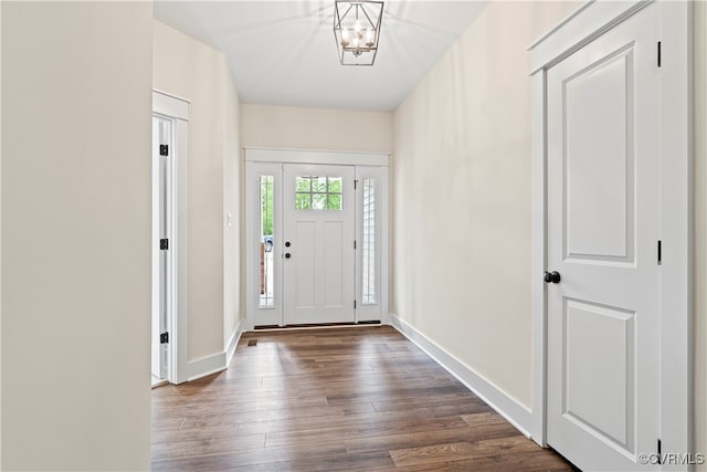 foyer with a notable chandelier and dark wood-type flooring