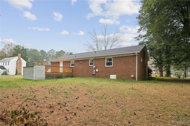 back of property featuring a lawn and a deck