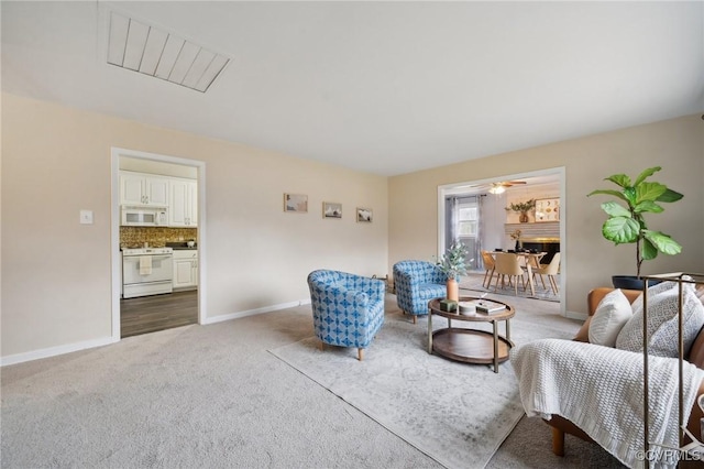 living room featuring carpet floors and ceiling fan