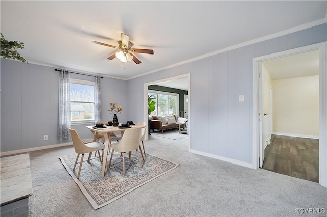 carpeted dining area featuring a wealth of natural light, ceiling fan, and ornamental molding