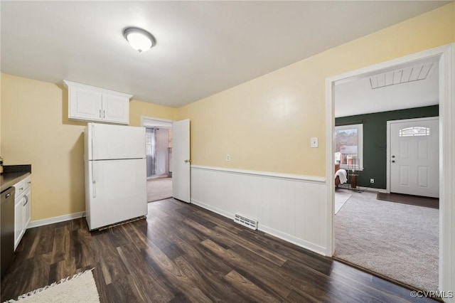 kitchen with white cabinetry, white fridge, stainless steel dishwasher, and dark hardwood / wood-style floors