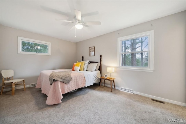 carpeted bedroom with multiple windows and ceiling fan