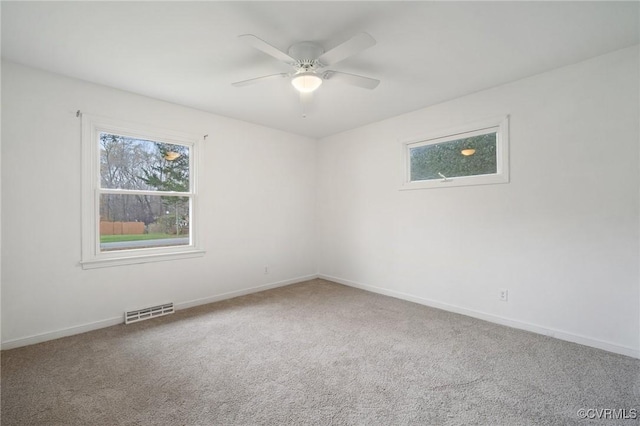 carpeted spare room featuring ceiling fan