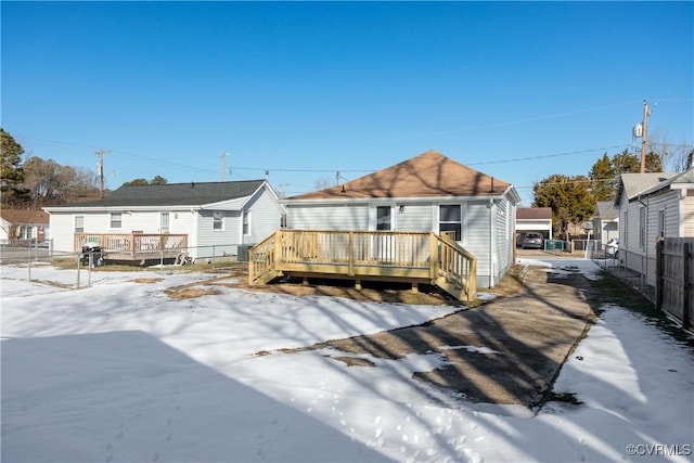 snow covered rear of property featuring a wooden deck