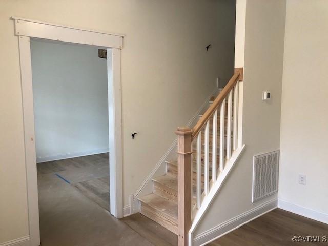 staircase with hardwood / wood-style floors