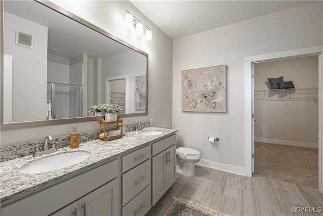 bathroom featuring vanity, toilet, and an enclosed shower