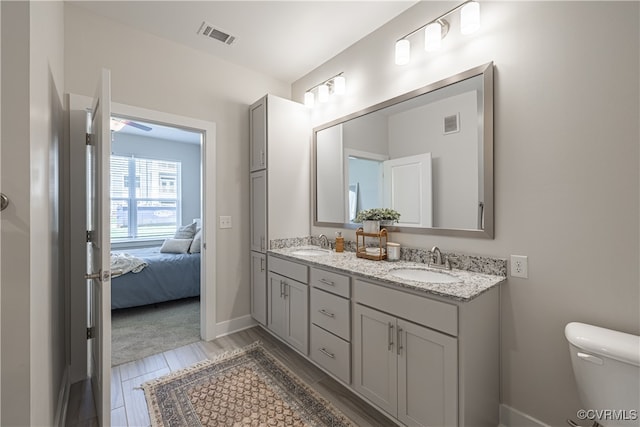 bathroom featuring wood-type flooring, vanity, and toilet