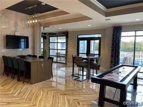 interior space featuring parquet flooring, a tray ceiling, and ornamental molding