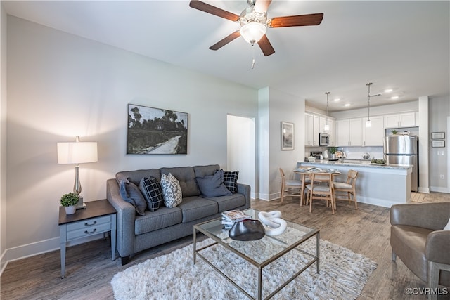 living room featuring ceiling fan and light hardwood / wood-style flooring