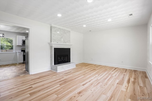 unfurnished living room with a fireplace and light hardwood / wood-style flooring