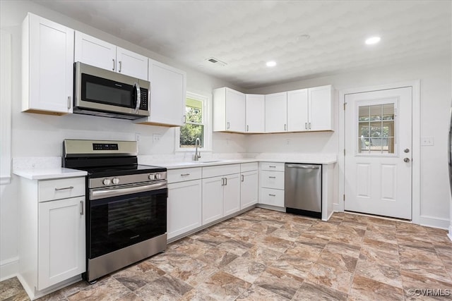 kitchen with white cabinets, sink, and appliances with stainless steel finishes