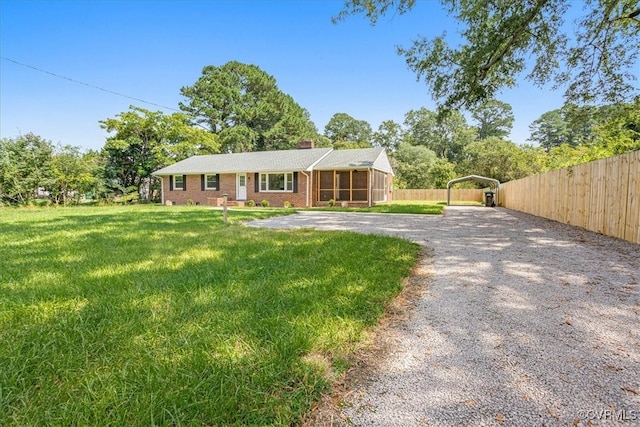 ranch-style house featuring a front lawn, a carport, and a sunroom