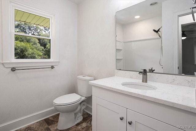 bathroom with a shower, vanity, toilet, and ceiling fan