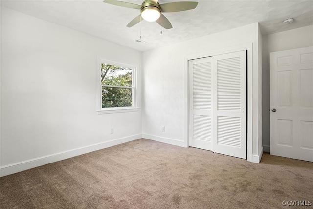 unfurnished bedroom featuring a closet, light colored carpet, and ceiling fan