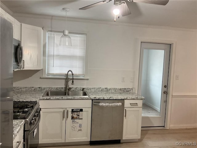 kitchen featuring sink, white cabinetry, stainless steel appliances, and hanging light fixtures