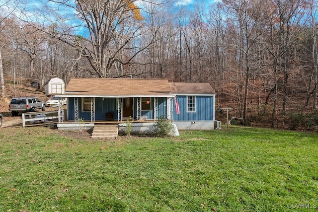 view of front facade featuring a storage unit, a porch, and a front yard