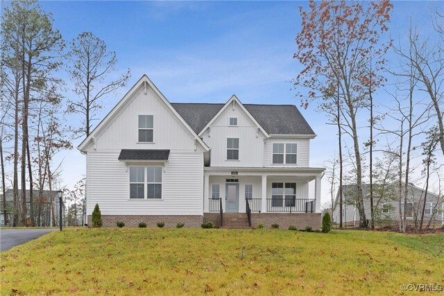 modern farmhouse style home with covered porch and a front yard