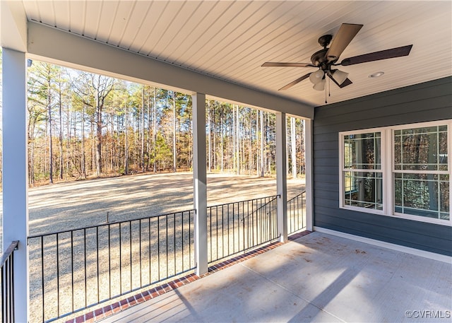 unfurnished sunroom featuring ceiling fan