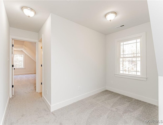 spare room with lofted ceiling and light carpet