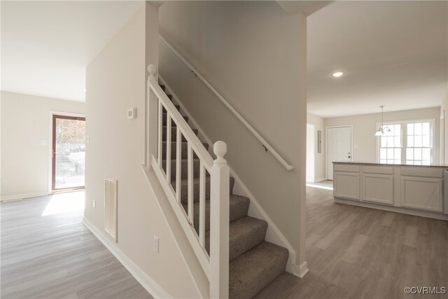 stairway featuring hardwood / wood-style floors and a healthy amount of sunlight