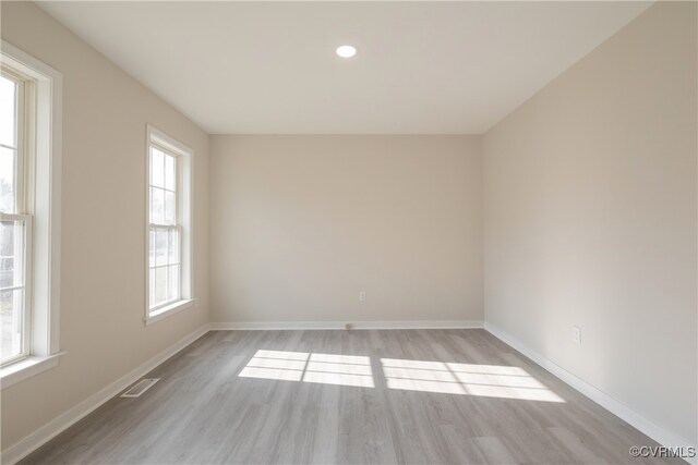 unfurnished room featuring light hardwood / wood-style floors and a wealth of natural light