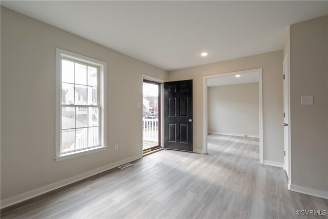 empty room with light hardwood / wood-style flooring