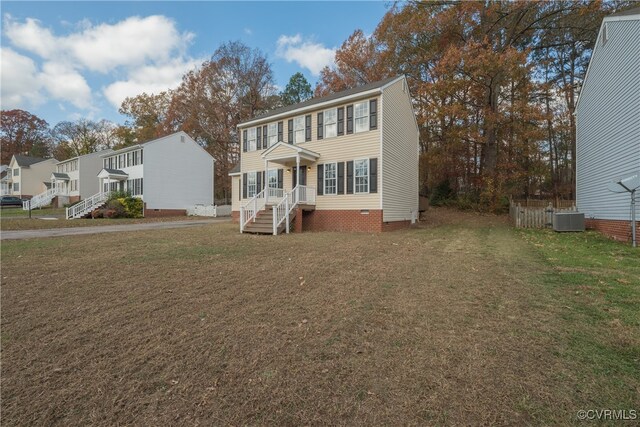 colonial house with a front yard and central air condition unit