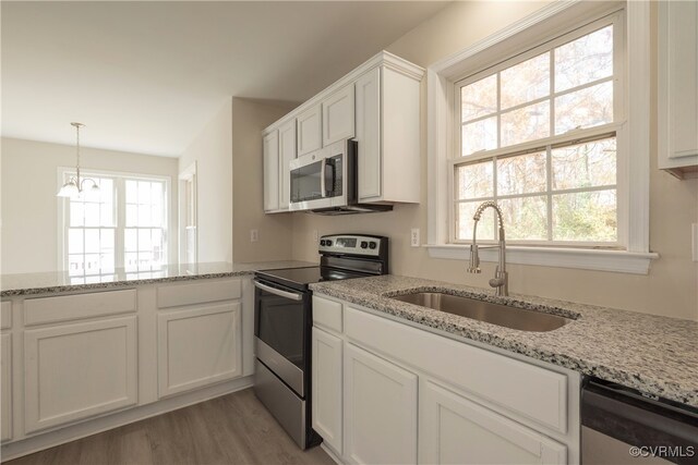 kitchen with plenty of natural light, light hardwood / wood-style flooring, stainless steel appliances, and sink