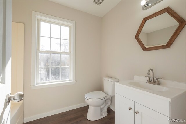 bathroom with hardwood / wood-style floors, vanity, and toilet