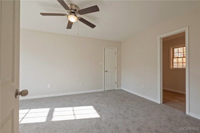 carpeted spare room with ceiling fan