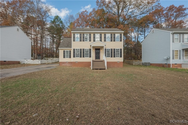 colonial home featuring central AC and a front lawn