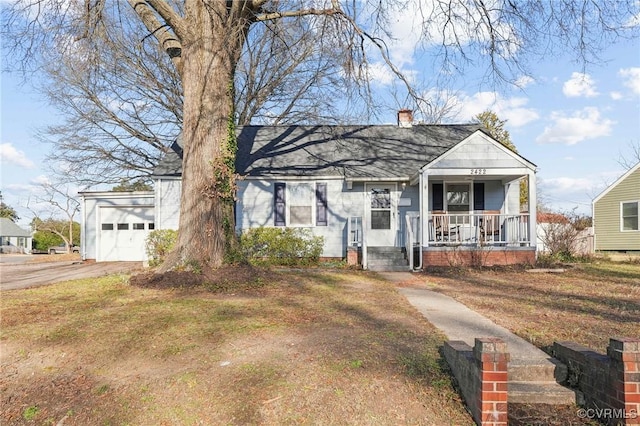 view of front of house featuring a porch, a garage, and a front lawn