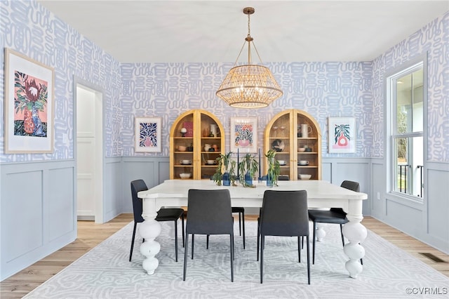 dining area featuring an inviting chandelier and light hardwood / wood-style flooring